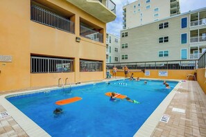 An indoor swimming pool with multiple lanes, surrounded by apartment buildings. - Wellington Unit 304 Condo (North Myrtle Beach)