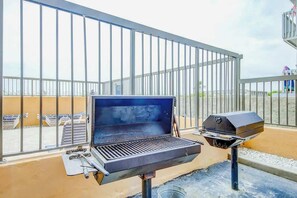 A rooftop barbecue grill with a built-in smoker, a grill cover, and a side burner. - Wellington Unit 304 Condo (North Myrtle Beach)