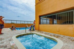A swimming pool area with a 3ft depth marker, a metal ladder, and a view of the sea. - Wellington Unit 304 Condo (North Myrtle Beach)