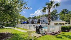 Uma área residencial com piscina, churrasqueira e um espaço de varanda coberto.