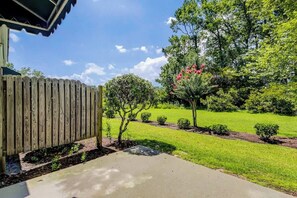 A residential property with a wooden fence, a concrete driveway, and a well-maintained lawn with small bushes and trees. - Albatross Beach Retreat (Little River)