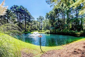 A pond with a 'NO FISHING' sign, surrounded by trees and grassy areas. - Golf Retreat Unit 832 (North Myrtle Beach)