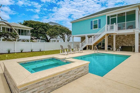 A backyard with a swimming pool, a covered patio, and a two-story house. - Grace by the Sea Retreat (Atlantic Beach)