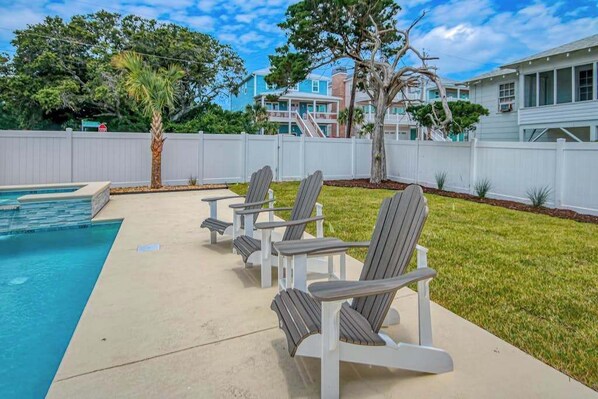 A poolside area with lounge chairs and a swimming pool. - Grace by the Sea Retreat (Atlantic Beach)
