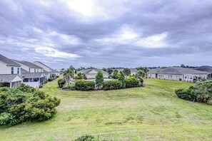 A residential area with houses, a grassy lawn, and a cloudy sky. - The Perfect Getaway at Wickham Dr (Myrtle Beach)