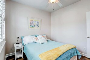 A bedroom with a bed, bedside table, and a ceiling fan. - Clearwater Bay Unit 1012 (North Myrtle Beach)