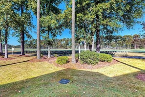 A park with trees, a grassy area, and a fence. - Paradise on the Course 303 (Myrtle Beach)