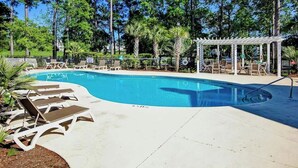 A swimming pool with lounge chairs and a covered seating area. - Paradise on the Course 303 (Myrtle Beach)