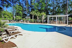 A swimming pool with lounge chairs and a covered seating area. - Paradise on the Course 303 (Myrtle Beach)