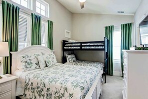 A bedroom with a bunk bed, a bedside table with a lamp, and a dresser. - Blue Wave Beach Retreat (Murrells Inlet)
