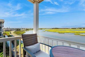 A balcony with a view of a river and green fields. - Cherry Grove Pelican's Watch (North Myrtle Beach)