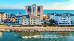 Ein Küstenhotel mit mehreren Gebäuden, einem Yachthafen und Blick aufs Meer.