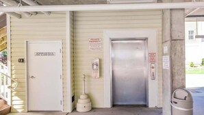 Entrada de propiedad privada con puerta de cuarto de alarmas contra incendios, un letrero de cuarto de rociadores y un contenedor de basura.