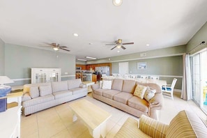 A spacious living area with two sofas, a coffee table, and ceiling fans. - Coconut Grove Unit 405 (North Myrtle Beach)
