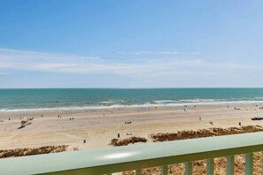 A beach with a clear sky, sandy shore, and a lifeguard tower. - The Pinnacle Unit 601 (North Myrtle Beach)