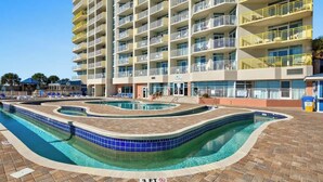 A multi-story hotel with a swimming pool area featuring a wavy pool design and a 3 FT depth marker. - Bay Watch Resort 0411 (North Myrtle Beach)