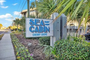 Schild mit der Aufschrift 'SEA CABIN' und dem Ort 'CHERRY GROVE'.