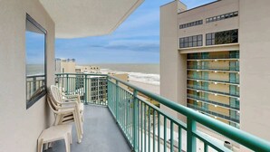 A balcony with a view of the beach and ocean, featuring a railing and a few chairs. - Sand Dunes Resort 910 (Myrtle Beach)