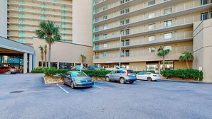 A multi-story hotel with a parking lot and several cars parked. - Sand Dunes Resort 910 (Myrtle Beach)