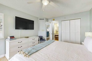 A bedroom with a bed, a dresser, a television, and a wardrobe. - Sand Dunes Resort 910 (Myrtle Beach)