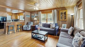 A cozy cabin interior with a kitchen, dining area, and living room. - The Little Brick Cottage (Murrells Inlet)