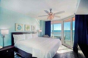 A hotel room with a bed, bedside lamps, a ceiling fan, artwork on the wall, and a balcony with a view. - Prince Resort Unit 1834 (North Myrtle Beach)
