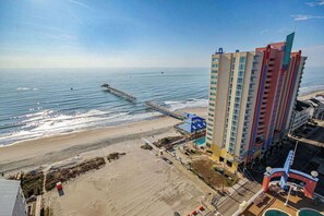 A coastal hotel with a pier extending into the sea, a beach, and a pool area. - Prince Resort Unit 1834 (North Myrtle Beach)