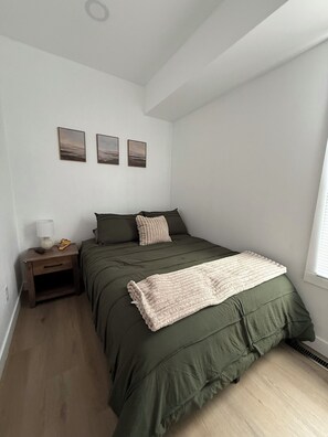 A bedroom with a bed, a nightstand, a lamp, and three wall-mounted pictures. - 3 Bedroom House Near Marion Square (Marion)