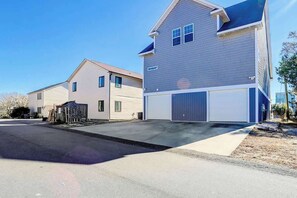 Eine Wohnstraße mit zwei Häusern, eines mit Garage und das andere mit einem kleinen Gartenhaus.