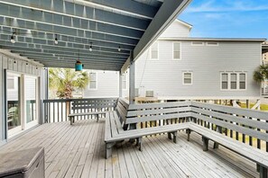 A covered outdoor deck with benches, a table, and a hanging light fixture. - Waccamaw Condo - Unit 6 (Murrells Inlet)
