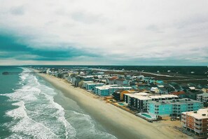 A coastal town with beachfront properties, a pier extending into the sea, and a clear sky. - Waccamaw Condo - Unit 6 (Murrells Inlet)