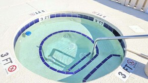Ein kreisrunder Whirlpool mit einem Durchmesser von etwa 90 Zentimetern, umgeben von einer gefliesten Kante, mit Schildern, auf denen '3 FT' und 'KEIN TAUCHEN' stehen.
