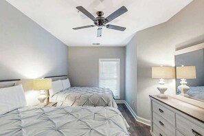 A bedroom with two beds, a ceiling fan, a dresser, and a window with blinds. - World Tour Sawgrass 205 (Myrtle Beach)