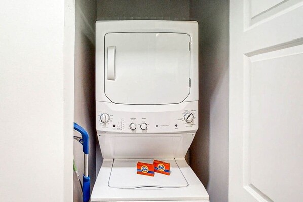 A white washing machine with Tide detergent boxes on top. - World Tour Sawgrass 205 (Myrtle Beach)