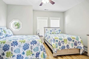 A bedroom with two beds, a ceiling fan, a window with blinds, and a wall-mounted plant. - Windy Lane Leisure Retreat (Pawleys Island)