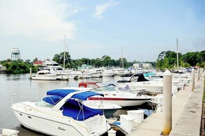 A marina with multiple boats docked, a water tower, and a dock with bollards. - The Sandy Oyster Retreat (North Myrtle Beach)