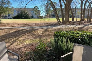 A park with benches, a pathway, and a building in the background. - The Sandy Oyster Retreat (North Myrtle Beach)