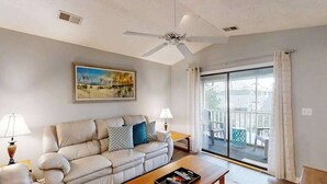 Ein Wohnzimmer mit einer Couch, einem Couchtisch und einem Bild an der Wand.