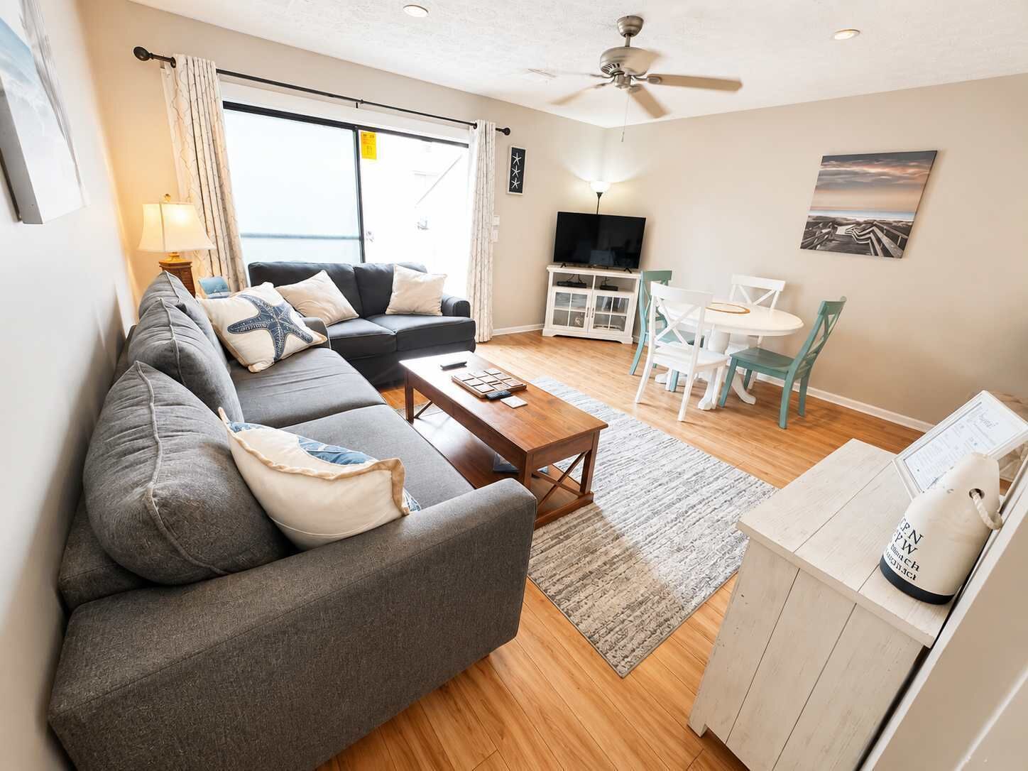 A modern living room with a sofa, coffee table, and a TV.