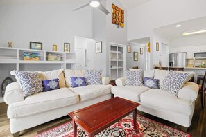 A living room with two white sofas, a coffee table, and a patterned rug. - Village at the Glens L-205 (Little River)