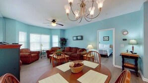 A spacious living room with a dining area, a chandelier, and a ceiling fan. - Homey Beach Hideaway C (Myrtle Beach)
