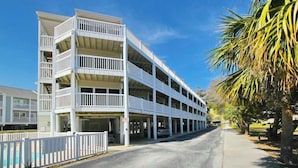 Ein mehrgeschossiges Parkhaus mit weißer Fassade und Balkonen.