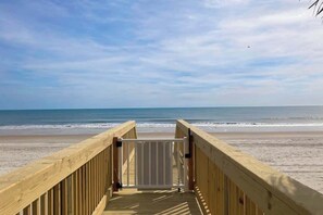 A wooden boardwalk leading to a beach with a gate in the center. - The Sand Shack - Litchfield Inn 251 (Pawleys Island)