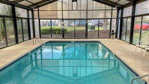A covered swimming pool with a view of the outdoors, including a lawn and a parked car. - Riverwalk Unit 301 Condo (Myrtle Beach)