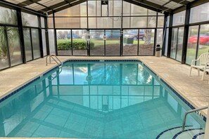 A covered swimming pool with a view of the outdoors, including a lawn and a parked car. - Riverwalk Unit 301 Condo (Myrtle Beach)