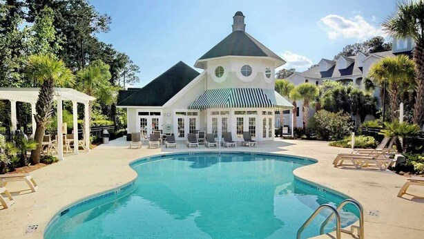 A pool area with lounge chairs and a gazebo. - Cypress Point Retreat 202 (Myrtle Beach)