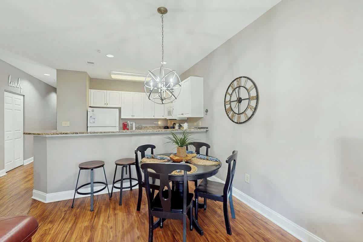 A dining area with a round table, chairs, and a chandelier.
