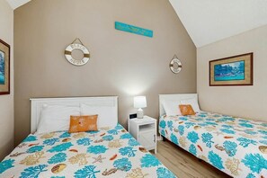 A bedroom with two beds, a nightstand, and a wall-mounted lamp. - Arcadian Dunes 18-370 (Myrtle Beach)
