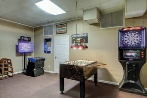 A room with a foosball table, a dartboard, and a television. - Arcadian Dunes 18-370 (Myrtle Beach)
