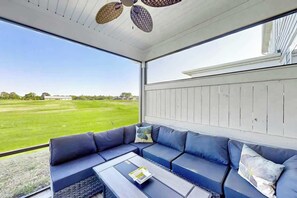 A covered outdoor seating area with a view of a green field. - Double Eagle Escape Retreat (North Myrtle Beach)